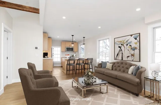 a living room with furniture kitchen view and a potted plant