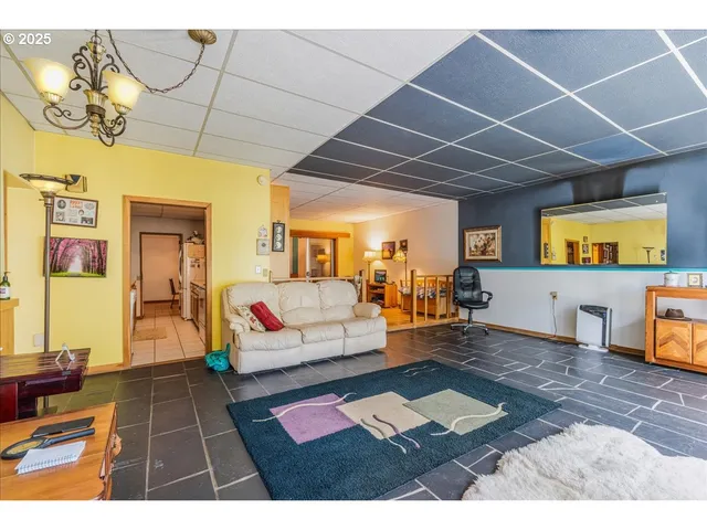 a living room with stainless steel appliances kitchen island granite countertop furniture and a flat screen tv