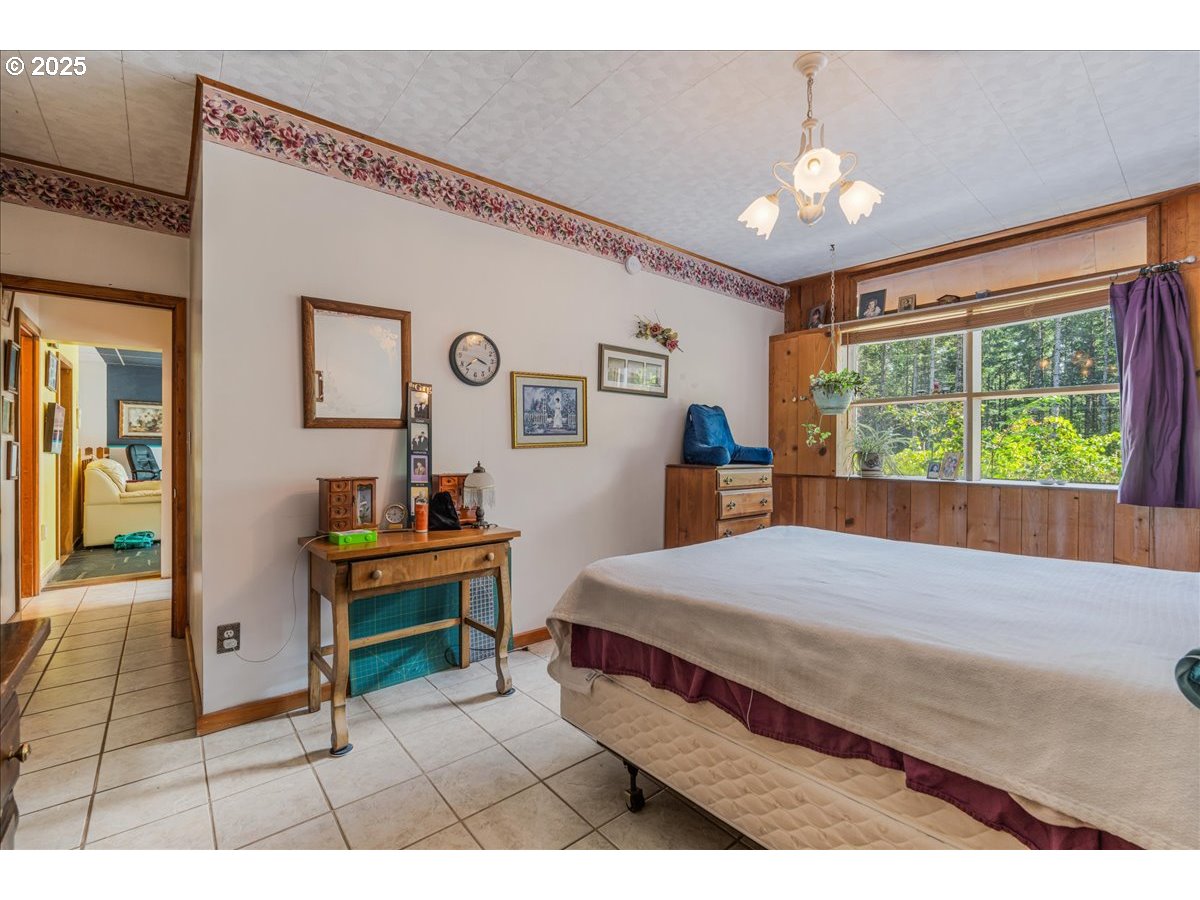 18175 Northeast Bald Peak Road Newberg, OR 97132 - Photo 25 of 41 a bedroom with a bed and a chandelier