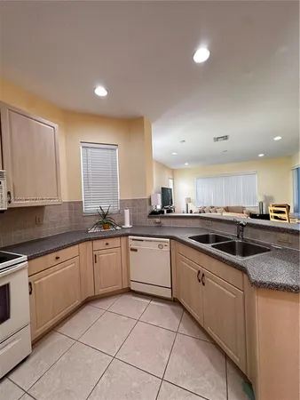 a large kitchen with granite countertop lots of white cabinets