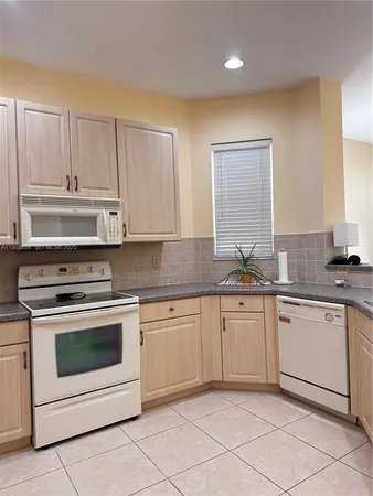 a kitchen with granite countertop white cabinets and white appliances