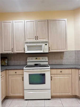 a stove top oven sitting inside of a kitchen