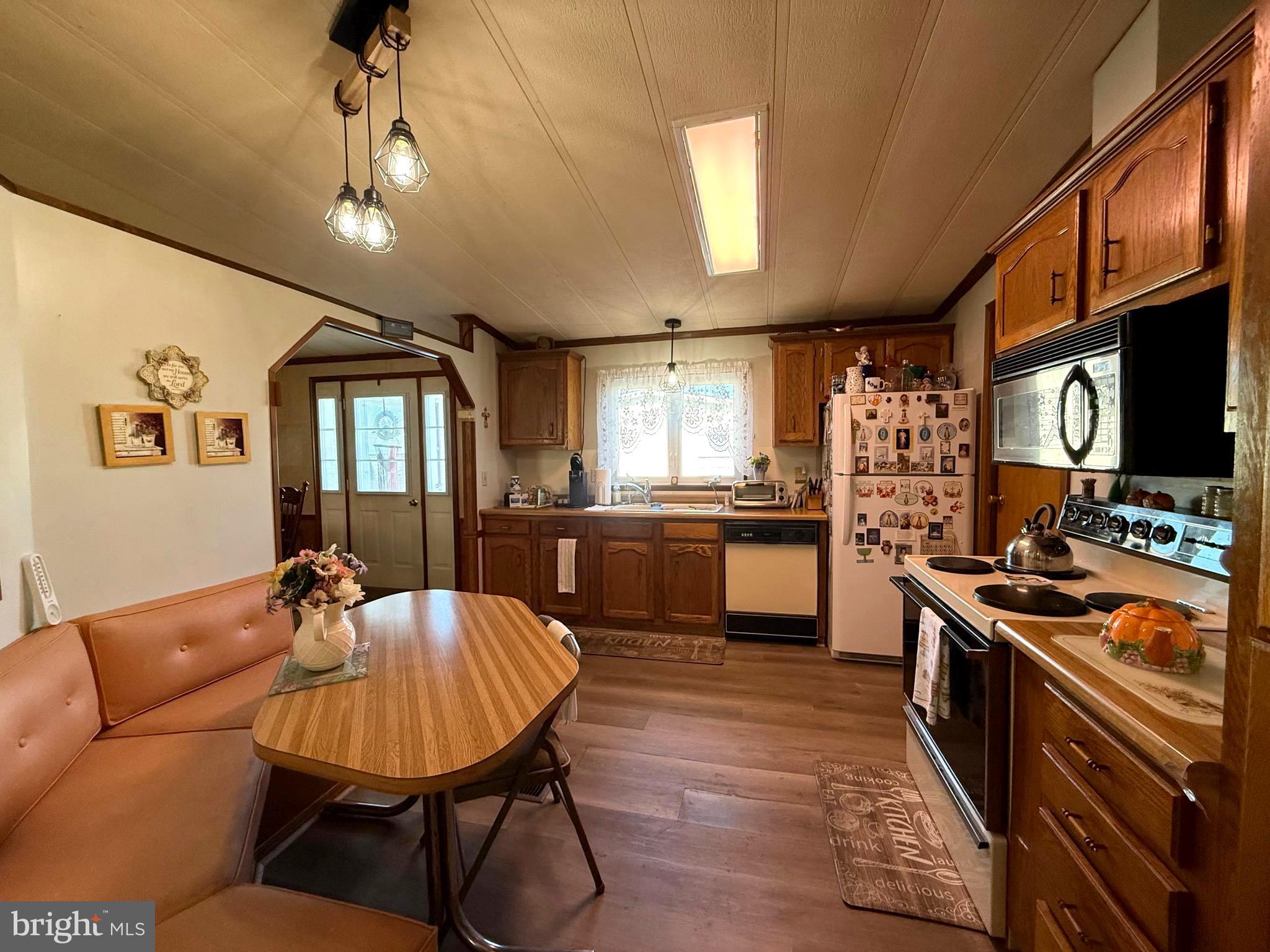 443 Priscilla Lane Buena, NJ 08310 - Photo 15 of 45 a kitchen with stainless steel appliances kitchen island granite countertop a stove a sink dishwasher a dining table and chairs with wooden floor