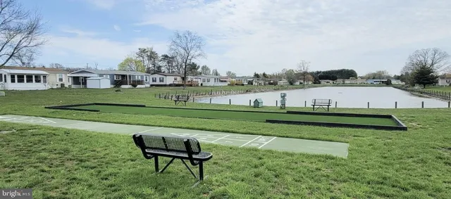 a view of a lake with a yard and large trees