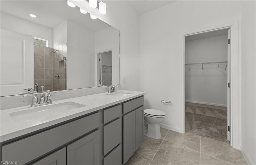 44357 Kelly Drive Punta Gorda, FL 33982 - Photo 13 of 24 a bathroom with a double vanity sink toilet and a mirror