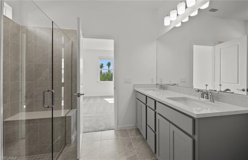 44357 Kelly Drive Punta Gorda, FL 33982 - Photo 14 of 24 a bathroom with a granite countertop sink a large mirror and a shower