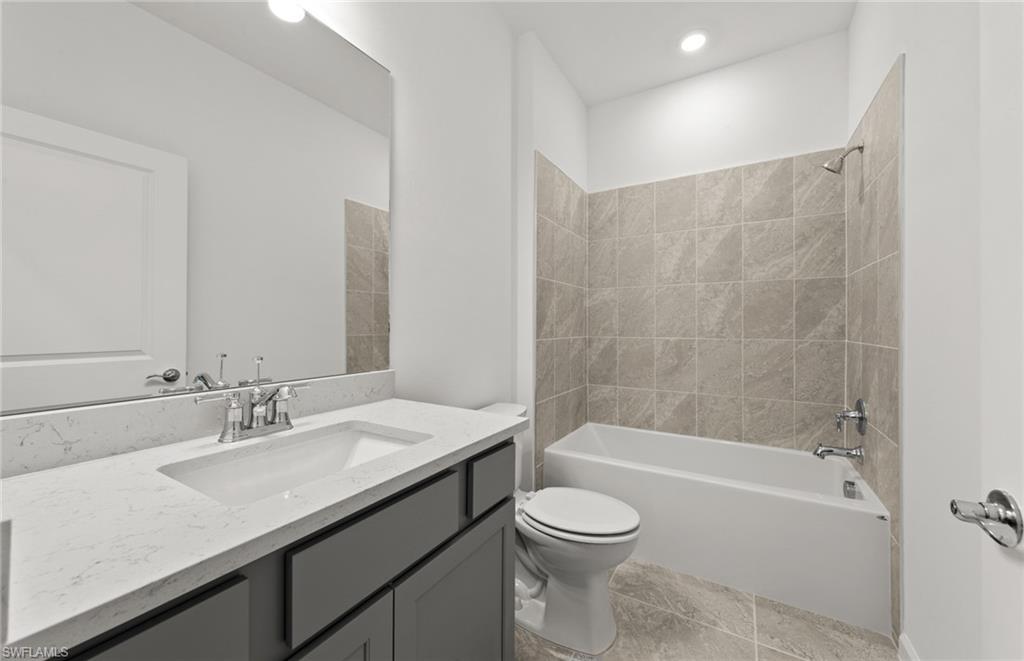 44357 Kelly Drive Punta Gorda, FL 33982 - Photo 18 of 24 a bathroom with a granite countertop sink a toilet and bathtub