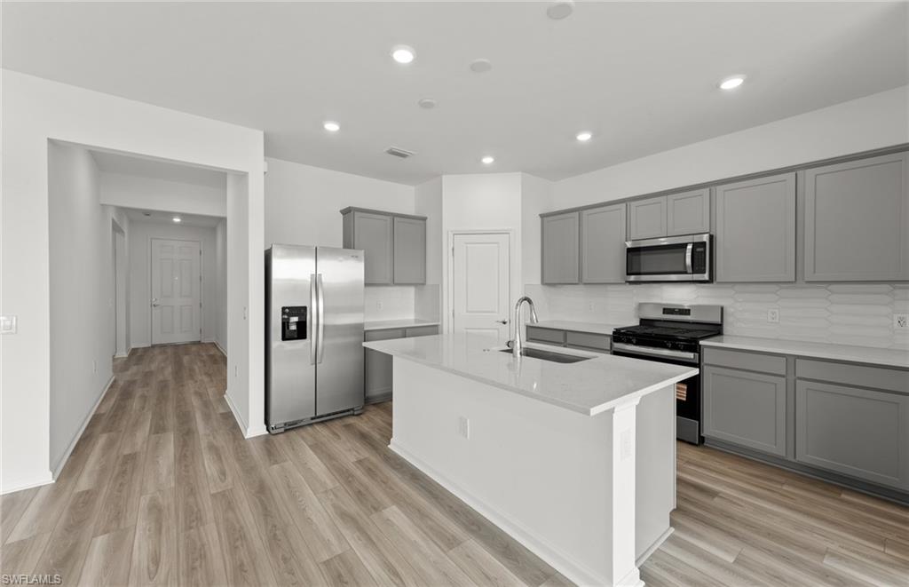 44357 Kelly Drive Punta Gorda, FL 33982 - Photo 4 of 24 a kitchen with cabinets stainless steel appliances and wooden floor