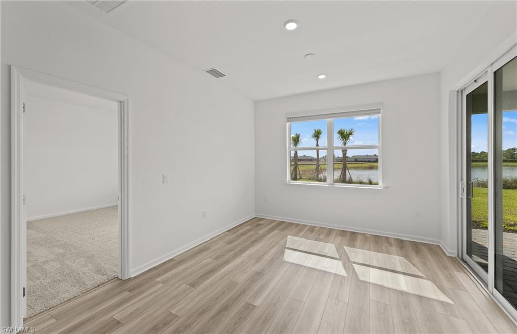 44357 Kelly Drive Punta Gorda, FL 33982 - Photo 8 of 24 an empty room with wooden floor and windows