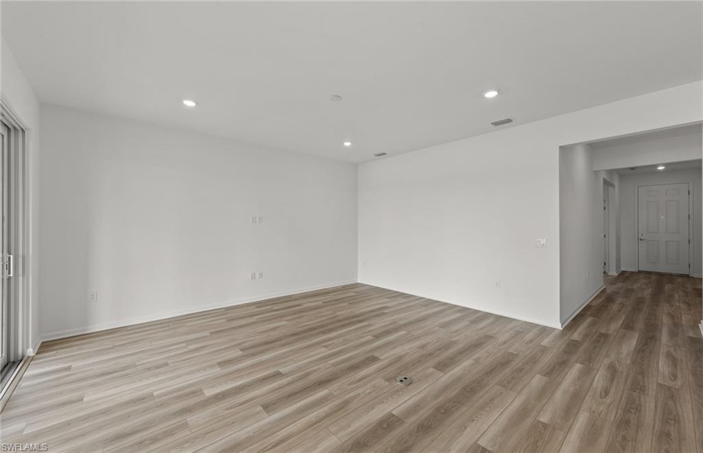 44357 Kelly Drive Punta Gorda, FL 33982 - Photo 9 of 24 an empty room with wooden floor and windows