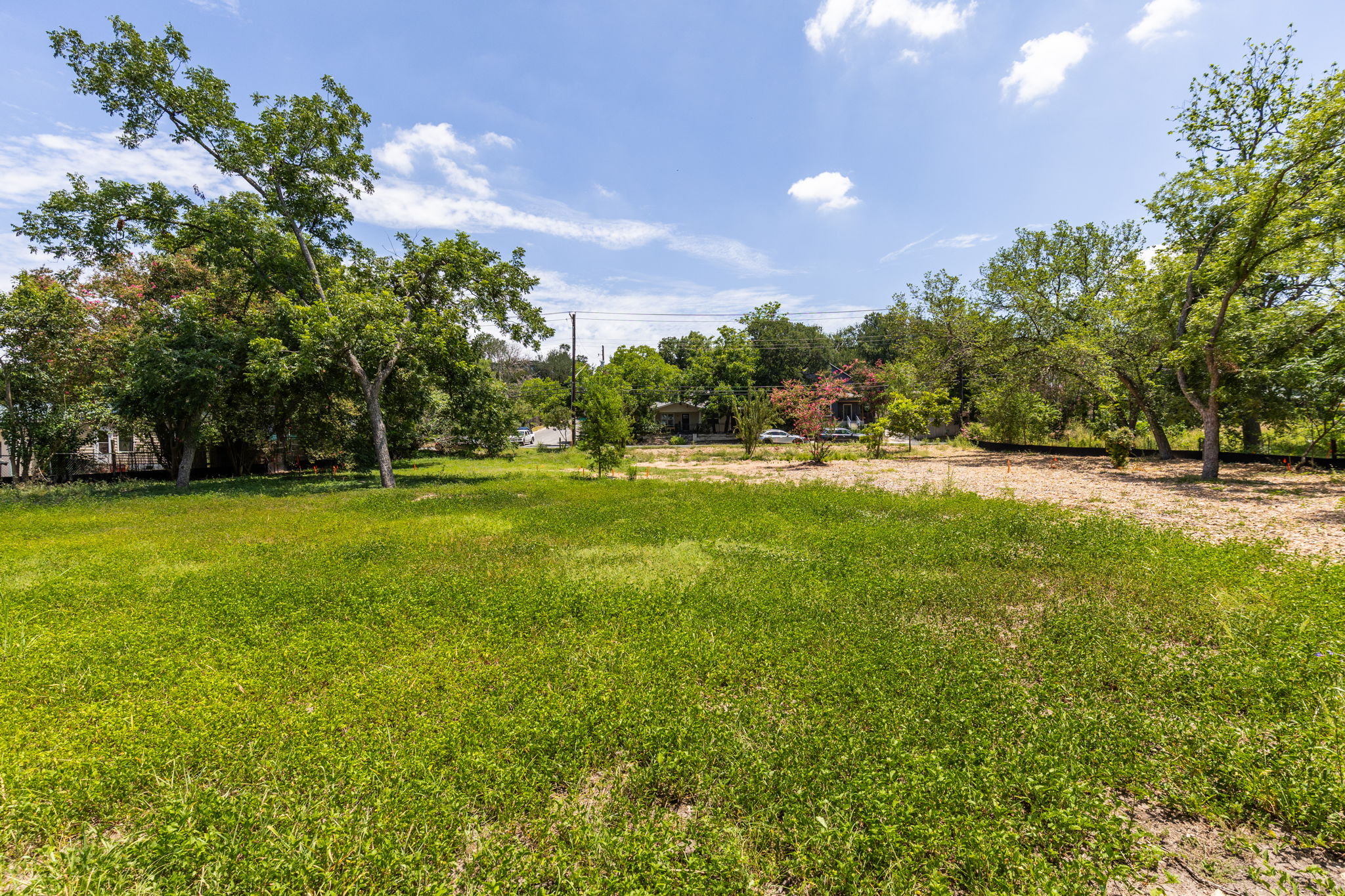 4801 Ledesma Road Austin, TX 78721 - Photo 19 of 24 A spacious, verdant lot awaits your vision, framed by mature trees and a sunny sky.