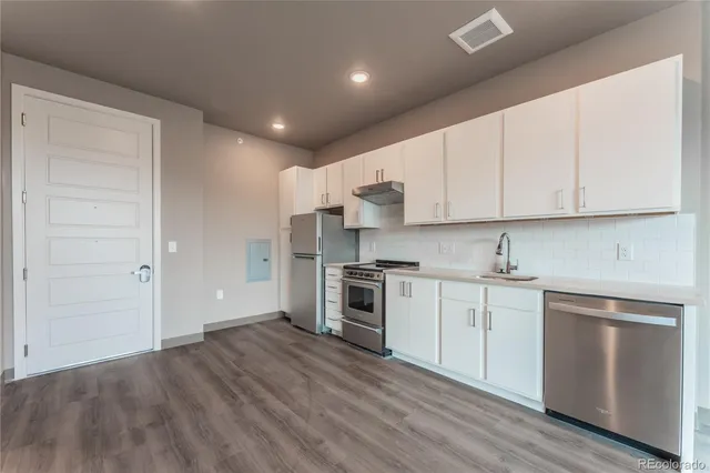 a kitchen with granite countertop white cabinets and stainless steel appliances