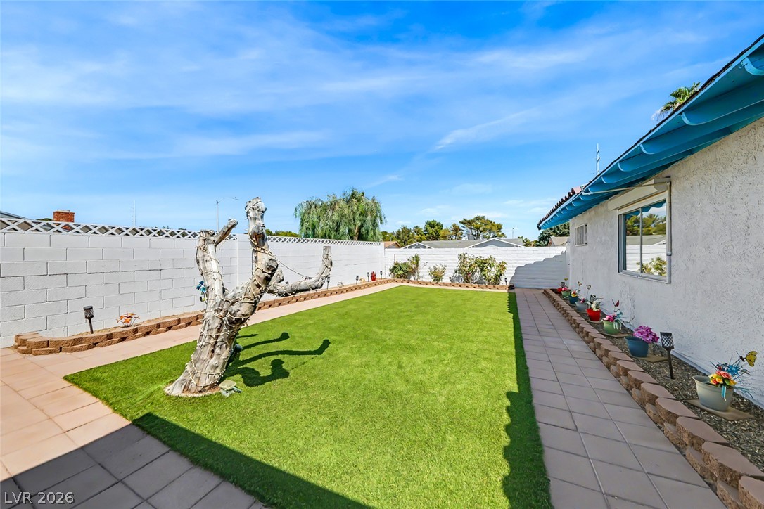 3107 Trueno Road Henderson, NV 89014 - Photo 5 of 37 A private, fenced backyard offers a serene oasis with ample green space and a convenient paved walkway.