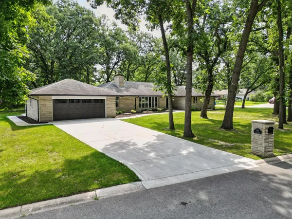 a front view of a house with a yard and trees