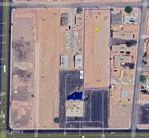 a view of a dry yard with wooden fence