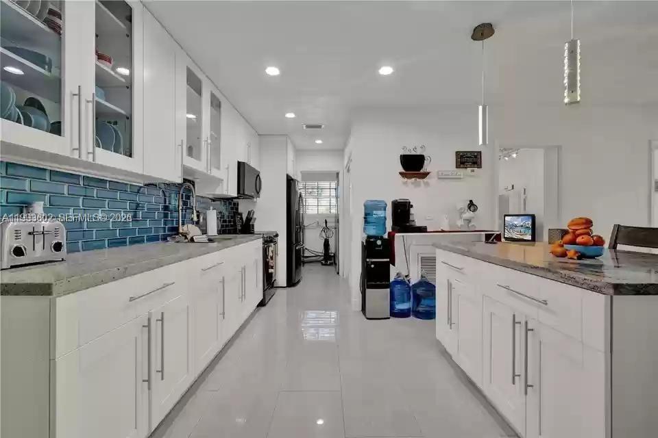 18441 Southwest 238th Street Homestead, FL 33031 - Photo 6 of 12 a kitchen with stainless steel appliances kitchen island granite countertop a sink and cabinets