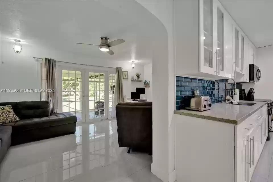 18441 Southwest 238th Street Homestead, FL 33031 - Photo 7 of 12 a kitchen with a refrigerator a stove a sink dishwasher with a dining table and chairs