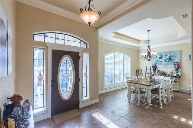 a view of a dining room with furniture a chandelier and window