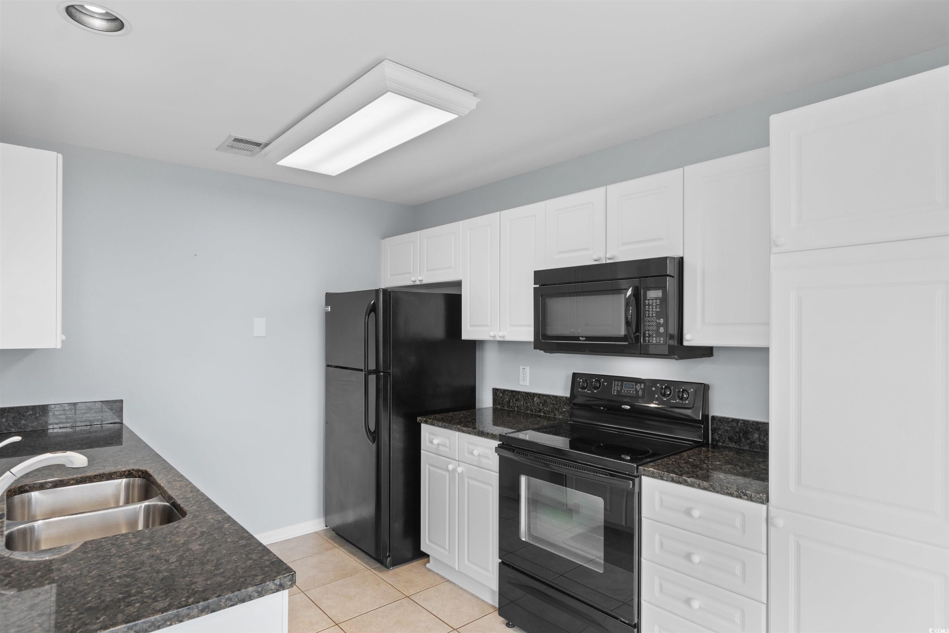 4430 Lady Banks Lane, Unit A2 Murrells Inlet, SC 29576 - Photo 7 of 31 Kitchen featuring black appliances, white cabinets, light tile patterned floors, and dark stone countertops