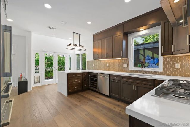 a kitchen with stainless steel appliances granite countertop a sink stove and refrigerator