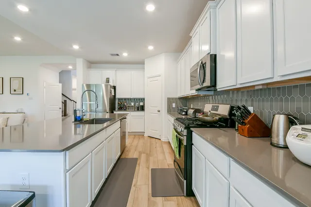 a kitchen with kitchen island granite countertop a sink and wooden cabinets