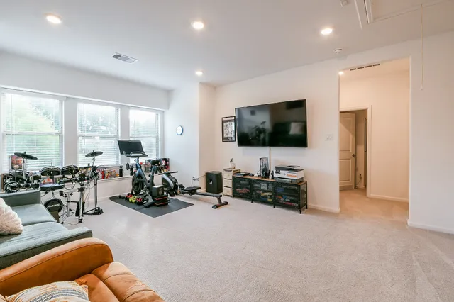 a living room with furniture gym equipment and a large window