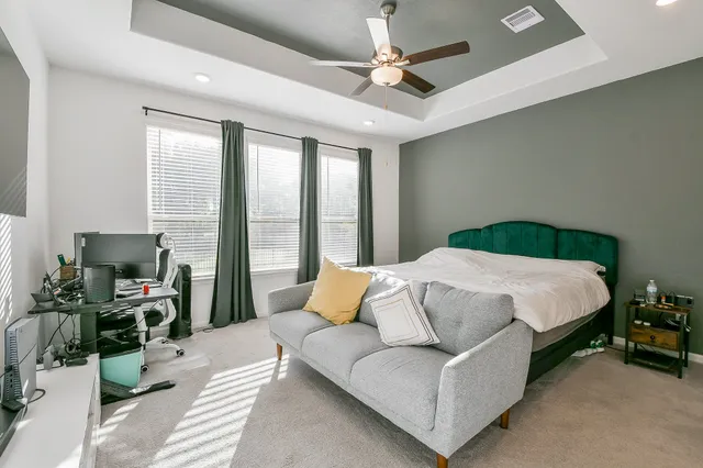 a bedroom with a bed couch and flat screen tv
