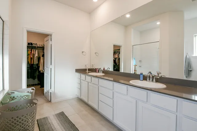 a bathroom with double vanity sinks and a mirror