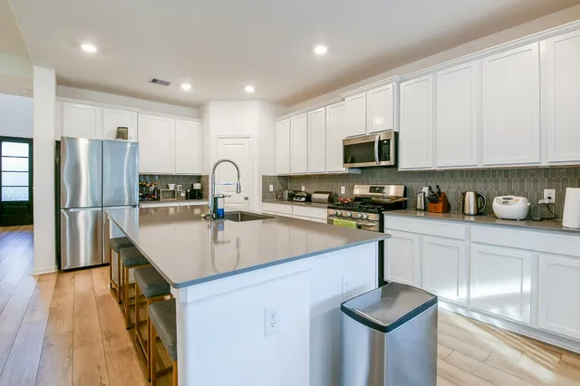 a kitchen with refrigerator a sink and a stove