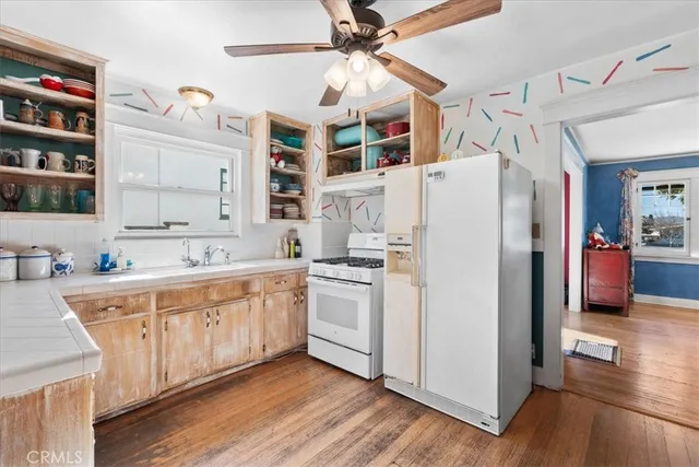 a kitchen with stainless steel appliances white cabinets and wooden floors