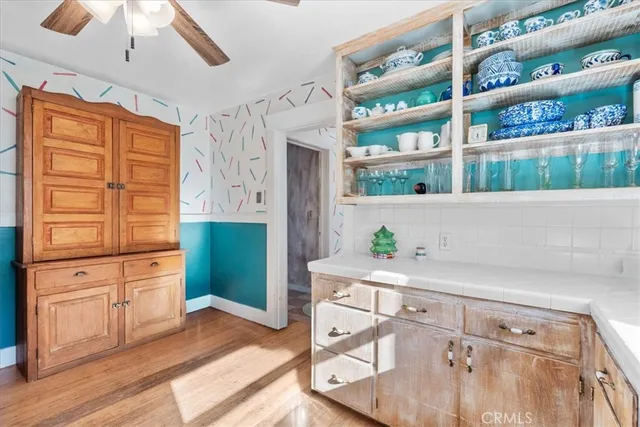 a living room with stainless steel appliances kitchen island granite countertop a refrigerator and a cabinets