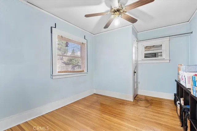 a view of an empty room with window and wooden floor