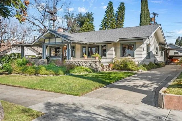 a front view of a house with a yard and potted plants