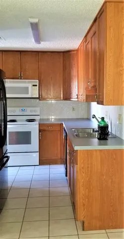 a kitchen with stainless steel appliances granite countertop a refrigerator a sink and a stove