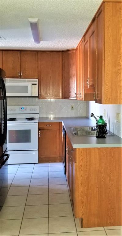 2200 East Trinity Mills Road, Unit 403 Carrollton, TX 75006 - Photo 6 of 20 a kitchen with stainless steel appliances granite countertop a stove a sink and a microwave