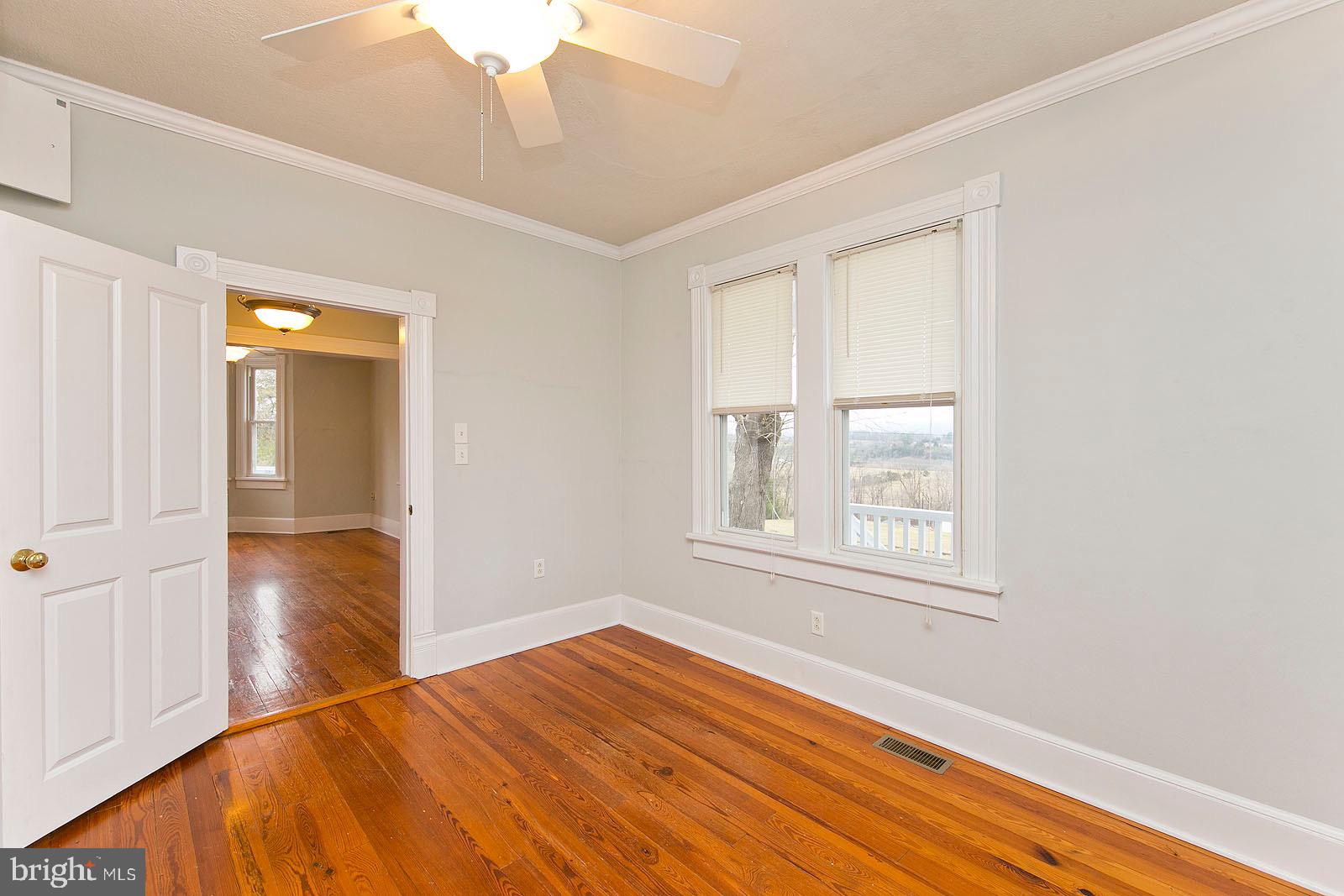 713 Rileyville Road Rileyville, VA 22650 - Photo 21 of 54 a view of empty room with wooden floor and fan