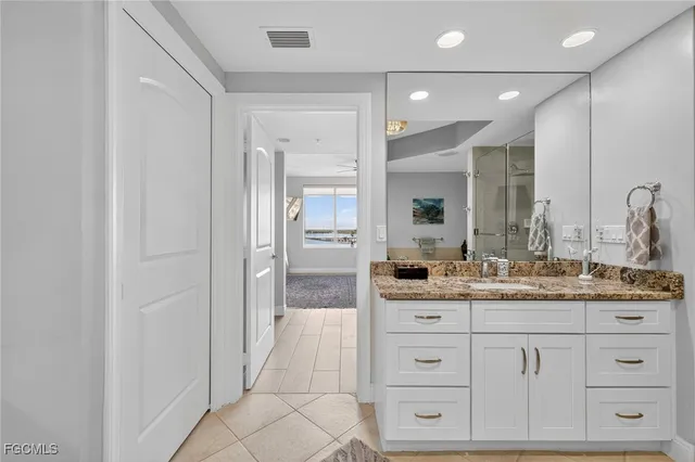 a bathroom with a granite countertop sink and a mirror