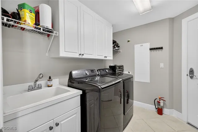 a utility room with cabinets washer and dryer