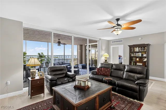a living room with furniture a ceiling fan and a window