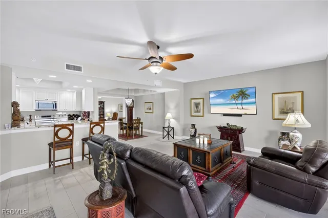 a living room with furniture kitchen view and a window