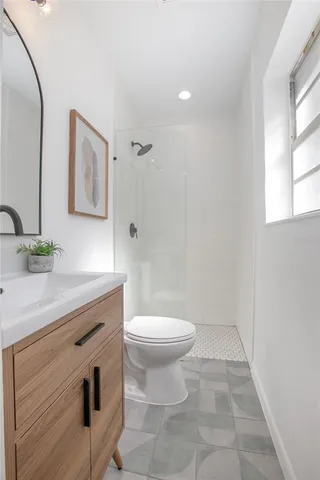 a bathroom with a sink a toilet and mirror