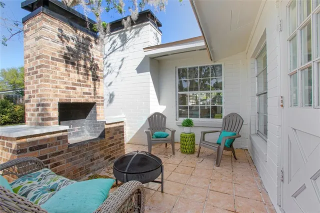 a view of a patio with couple of chairs and a fireplace
