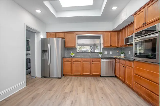 a kitchen with stainless steel appliances a refrigerator sink and microwave
