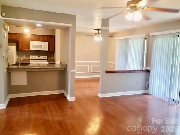 a view of a kitchen with wooden floor and a window