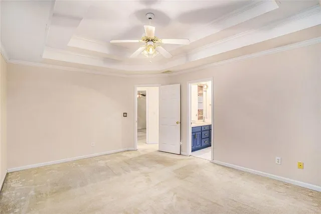 an empty room with chandelier fan and windows