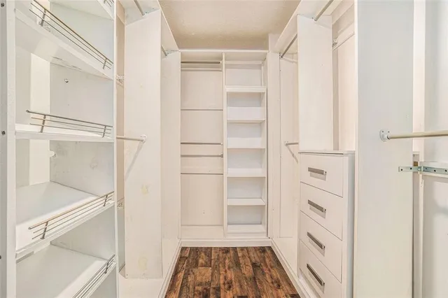 a view of walk in closet with empty racks