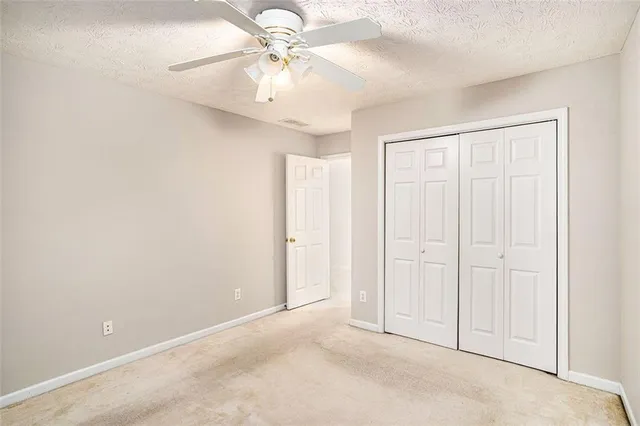 an empty room with a ceiling fan and a window