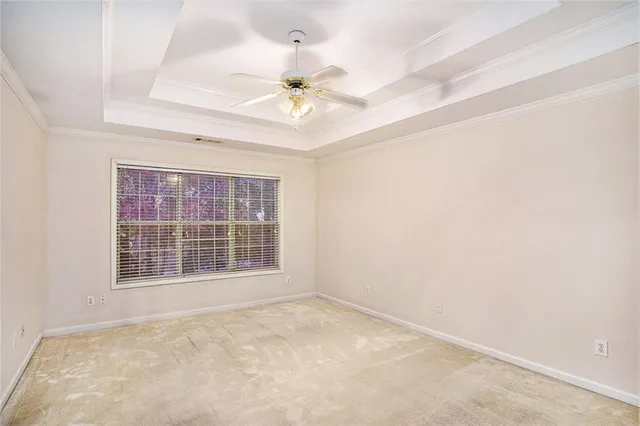 an empty room with a window and a ceiling fan