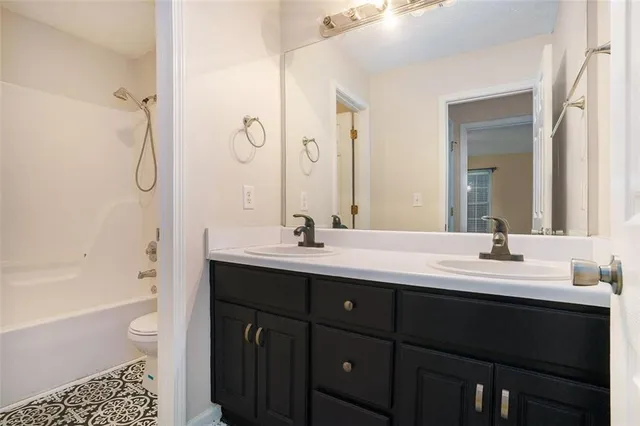 a bathroom with a double vanity sink toilet mirror and bathtub