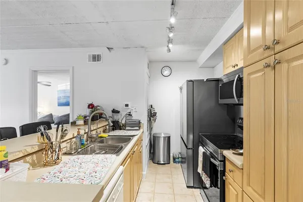 a kitchen with stainless steel appliances granite countertop a refrigerator a stove and a sink
